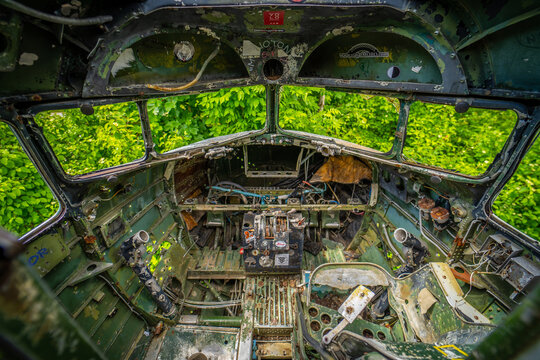 View of the abandoned cockpit of a Douglas C-47 Dakota aircraft with peeling paint and overgrown vegetation at Zeljava Aerodrome in Zeljava, Licko-senjska zupanija, Croatia.