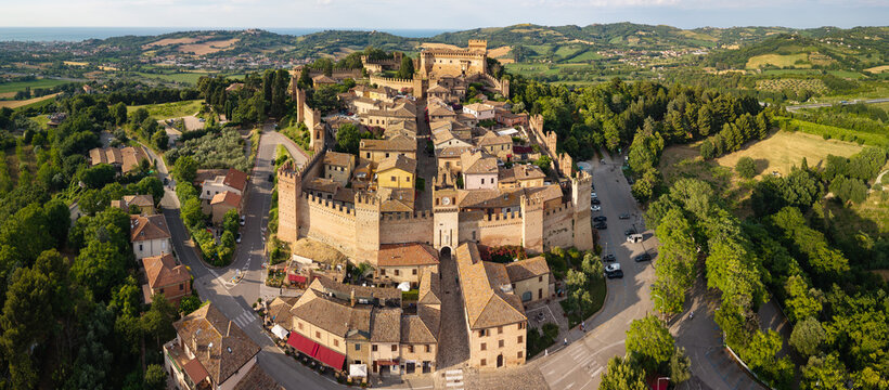 Gradara Italy  Aerial. Drone view of medieval borgo fortress and castle on green hills with blue sea background. Scenic Marche Pesaro Urbino historic townscape travel asset