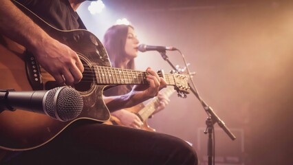 Obraz premium Close-up of hands playing an electric guitar with microphone