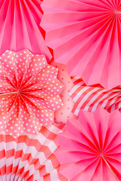 Colorful paper decorations are arranged on a surface for a party or celebration event