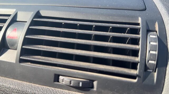 Close-up of central air vents and hazard button on a car dashboard, vehicle ventilation controls, automotive interior, driving equipment.