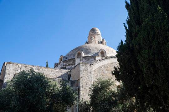 Jerusalem, Israel, June 13, 2026. A detailed close-up shot of the architectural stone dome and tower of the YMCA building framed by green trees.