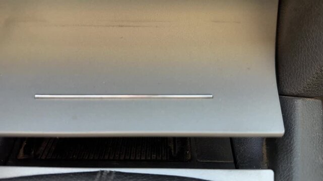 Sliding cover opens and closes the center storage compartment inside a car, cabin organization, vehicle interior mechanism, automotive convenience.