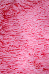 Fototapeta premium Bright pink fluffy fabric lays flat on a surface, showing texture and color at close range