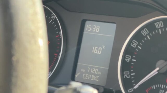 Close-up of a car instrument cluster showing speedometer, digital clock, fuel level and odometer mileage, driver information, dashboard controls, vehicle monitoring.