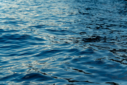 Abstract blue water surface with ripple pattern and reflection