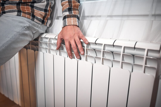 Man heating on a chilly winter day, energy and gas crisis, cold room, heating problems.