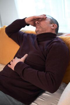 Man with gastritis, chest, stomach and abdominal pain at home.