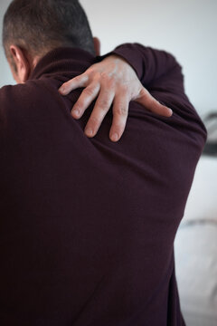 Man with neck, muscle, back and sciatica pain at home.
