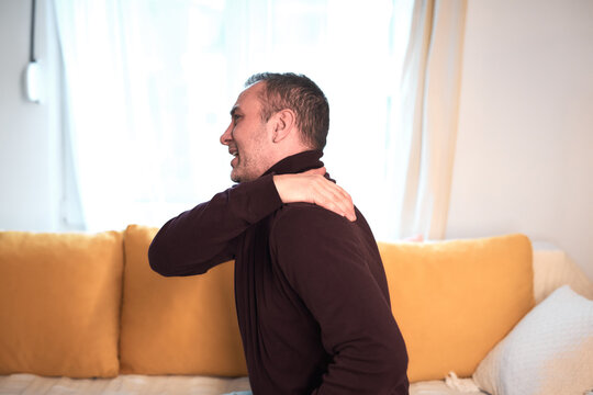 Man with neck, muscle, back and sciatica pain at home.