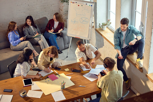 Creative startup team working on solution strategy during office workshop. Concept of team planning session, business problem solving, design thinking, innovation workflow, startup training.