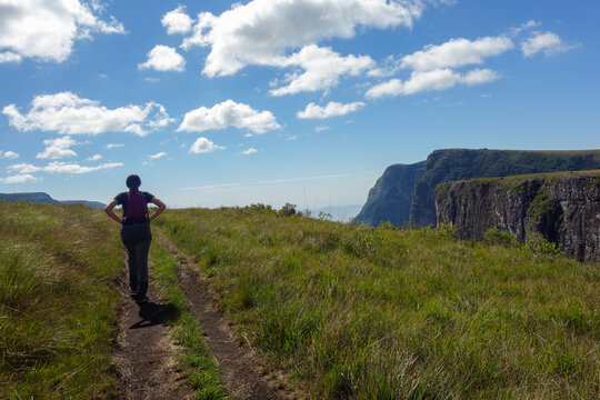 woman walks along trail in Fortaleza canyon park, Cambara do Sul, RS, Brazil. 