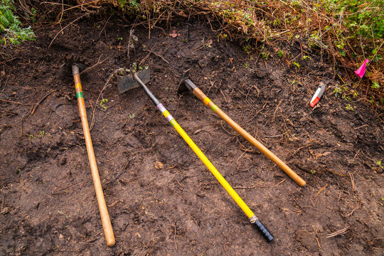 landscaping equipment shovels laying in dirt