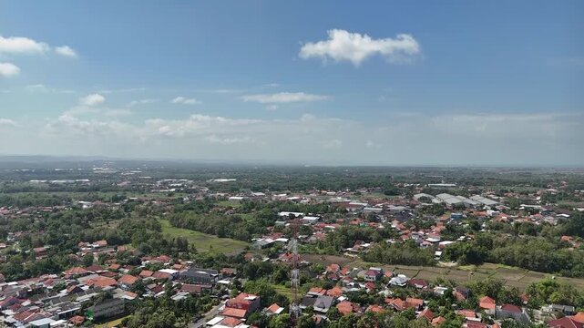 Aerial Drone Shot of Residential Housing and Small Town Landscape in Indonesia under Bright Blue Sky