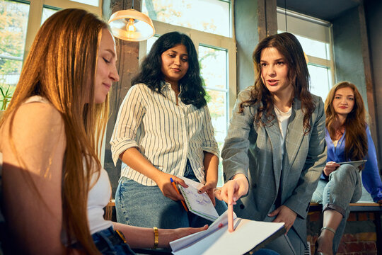Creative team discussing ideas during informal office meeting. Concept of brainstorming session, team planning, startup culture, business communication, group feedback.