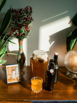 Fresh kombucha on wooden dresser in sunlight 