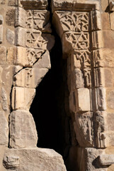 Obraz premium Damaged ancient stone architecture in the Middle East. Ruins of historic building after conflict. Architectural destruction and violence concept. Symbol of war and cultural heritage loss.