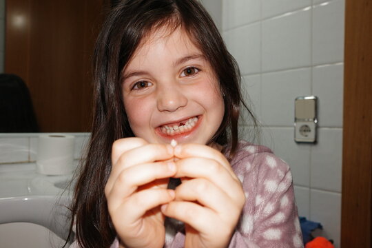 Excited Child Celebrating Lost Tooth in Bathroom