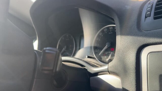 Driver attempts to start a car as dashboard indicators illuminate and flash, ignition sequence, possible starting issue, vehicle diagnostics, automotive repair.