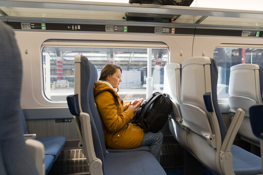 Woman Using Phone Inside a Train While Traveling