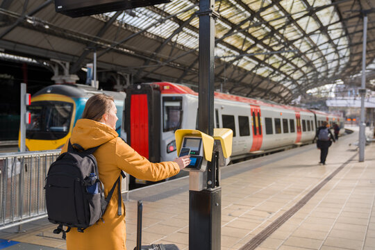 Person Uses Phone to Make Payment at Train Station