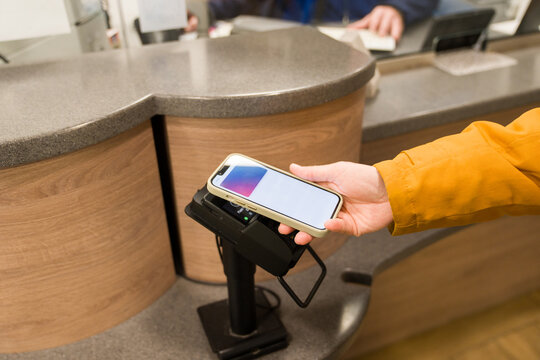 Person Uses Phone to Make Payment at Service Counter