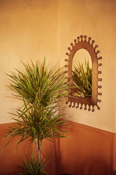 Mediterranean style interior with palms, gold mirror and plaster walls