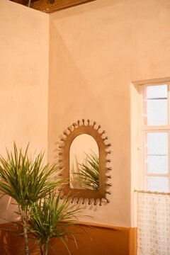 Mediterranean style interior with palms, gold mirror and plaster walls