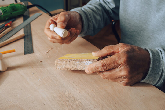 Old Carpenter Working with Sandpaper
