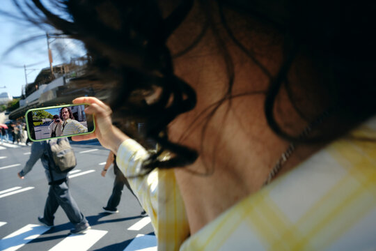 POV of Traveler filming friend on Tokyo city street with smartphone