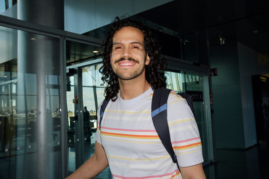 Smiling traveler walking inside Helsinki Airport terminal