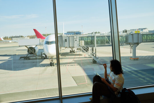 Traveler drawing near airplane gate at Helsinki Airport