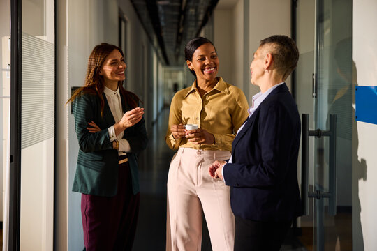 Elegant women conversing in the office corridor