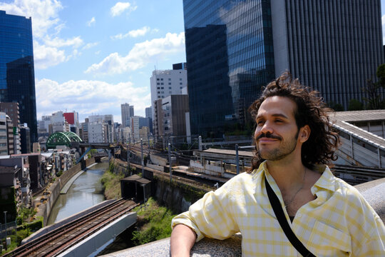 Traveler overlooking Tokyo cityscape and railway tracks