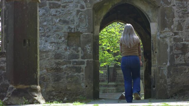 Woman tourist walking in archway of Saint Thomas a Becket Abbey Church 