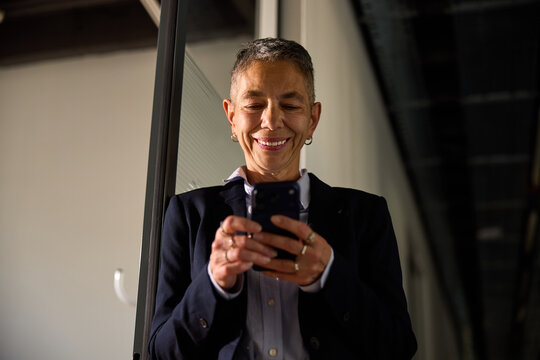 Senior woman holds a mobile phone inside the corporation