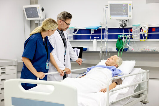 Doctor Talks to Nurse and Patient in Hospital Room