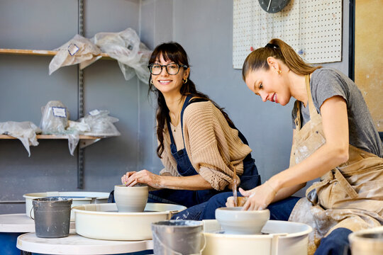 Two women create pottery together