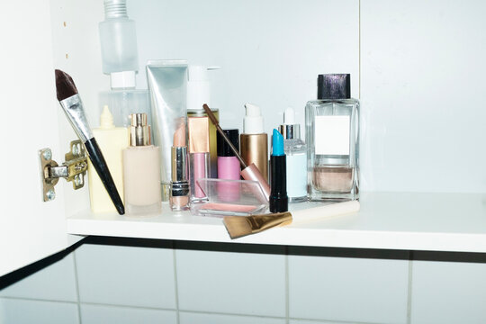 Shelfs full of make up and beauty products in bathroom with flashlight