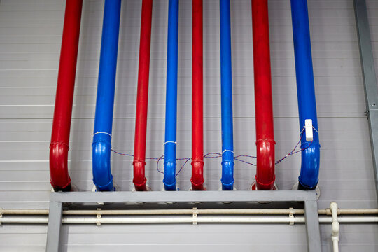 Vivid blue and red water supply pipes illustrating infrastructure and functionality, ideal for projects related to plumbing, construction, and urban development.