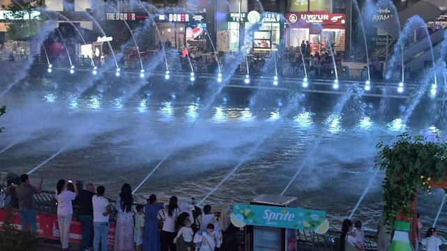 Tashkent, Uzbekistan - June 08, 2026: Seoul Mun Street.  Colorful fountain show with spectators enjoying evening performance.