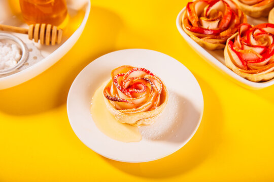 Rose-shaped apple dessert on yellow background
