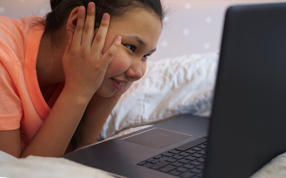 Teen girl using laptop at home for online learning