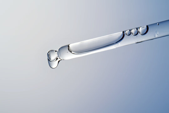Cosmetic serum dropping from pipette for skin care