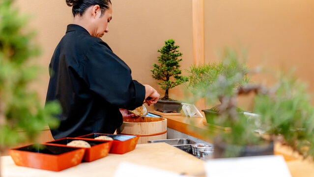 Sushi chef preparing nigiri at Japanese restaurant in Tokyo