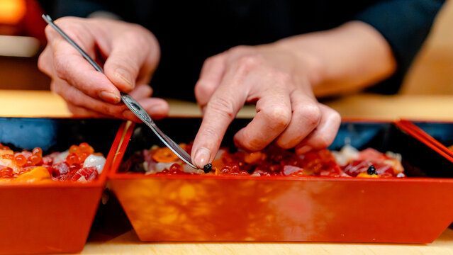 Chef finishing chirashi sushi with caviar and Uni in Tokyo