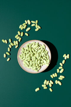 Top view of verdina beans in bowl on green backdrop
