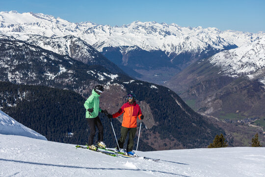 Couple skiing together on snowy mountain slope