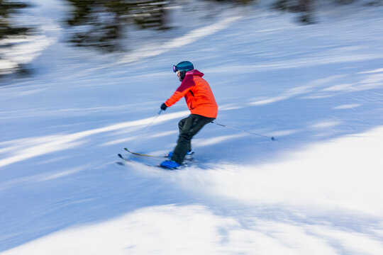 Skier enjoying a fast descent on snowy slope