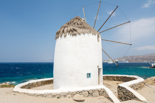 Traditional Mykonos windmill by the Aegean sea in Greece